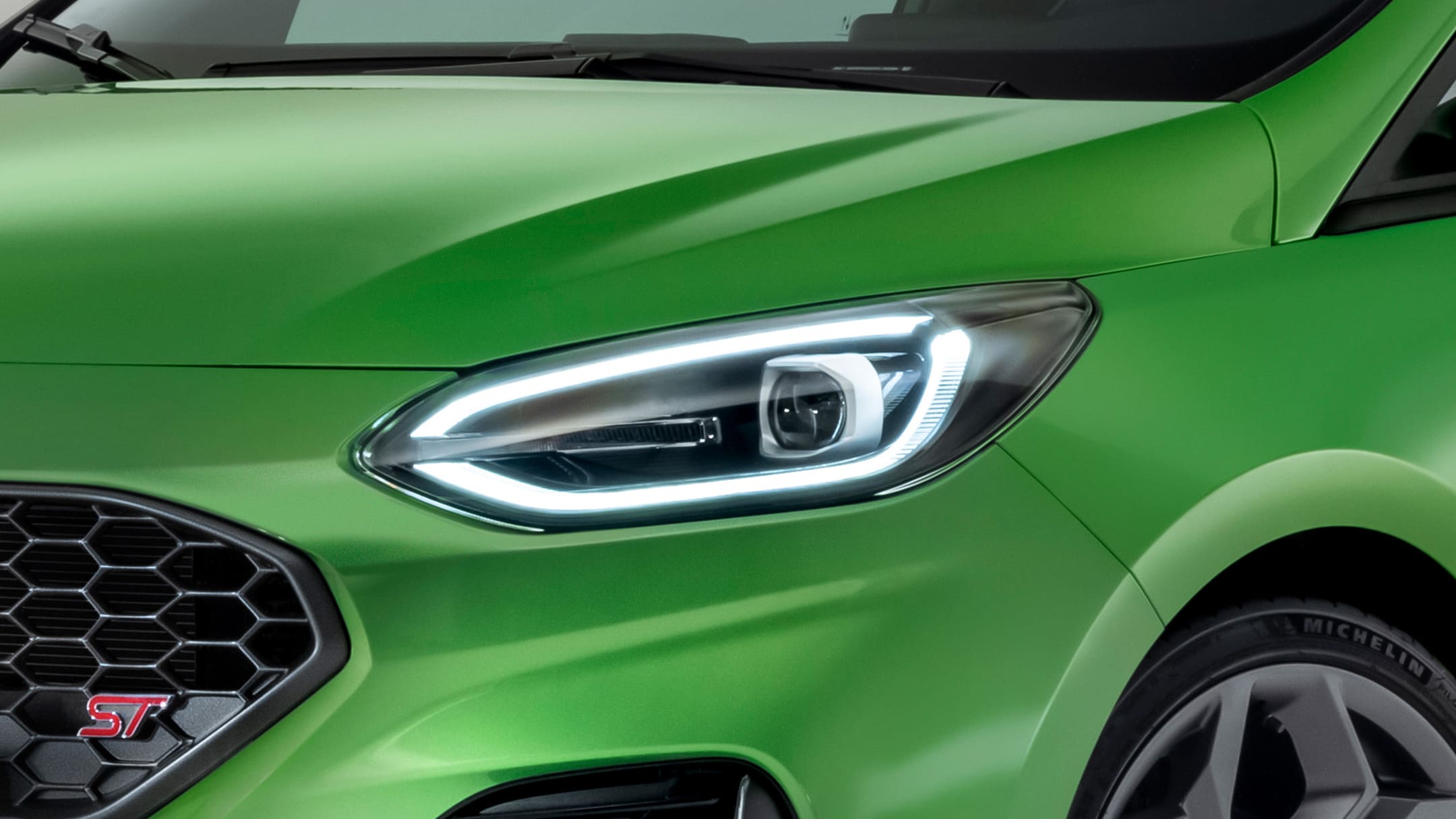 Ford Fiesta ST couleur verte. Vue détaillée d’un phare avant.