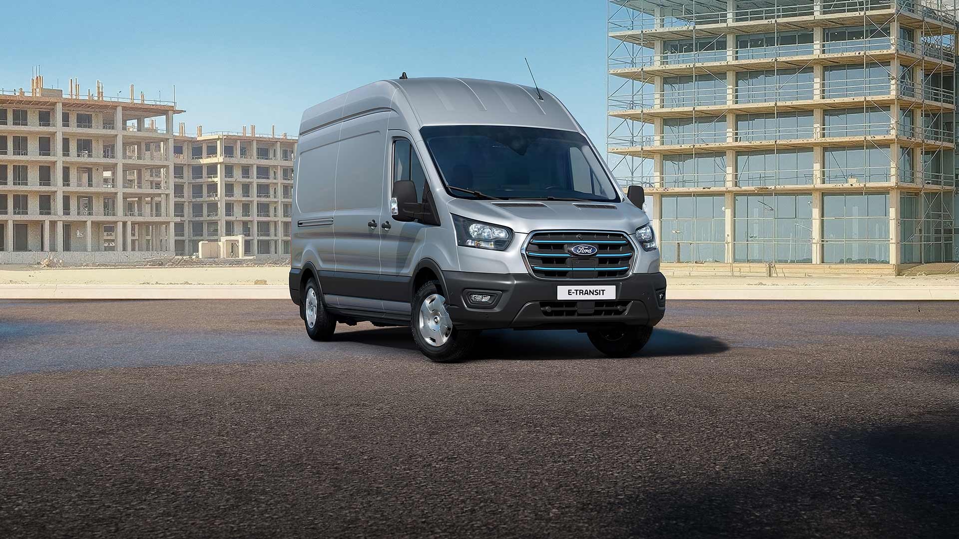 Un Ford E-Transit gris stationné sur une route.