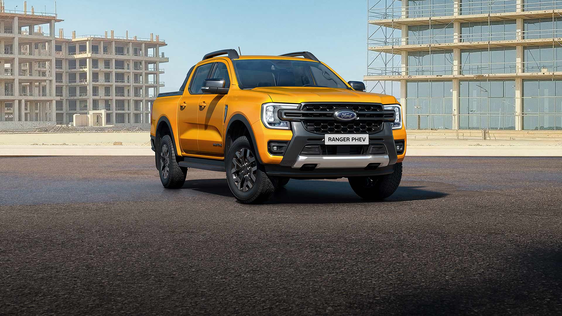 Un Ford Ranger PHEV jaune stationné sur une route.