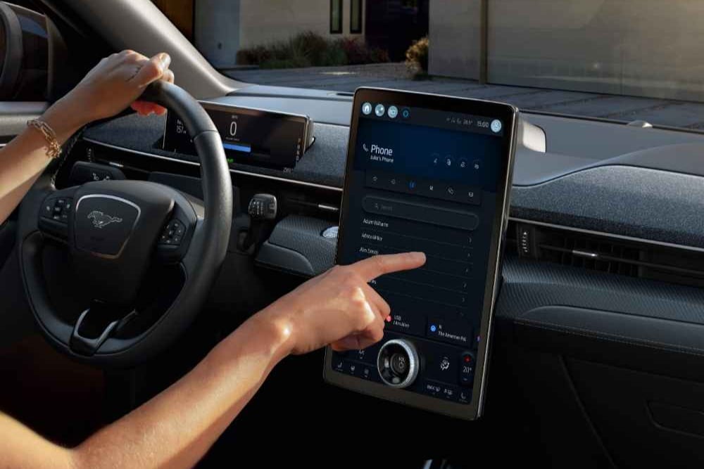 Gros plan sur le conducteur d’une Ford Mustang Mach-E interagissant avec le grand écran tactile SYNC 4 de 15,5"
