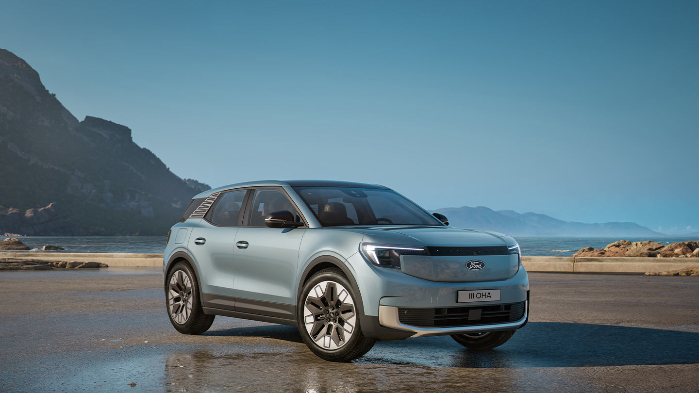 Vue de trois quarts avant d'un Ford Explorer argenté, stationné près d'un plan d'eau, avec des montagnes en arrière-plan.