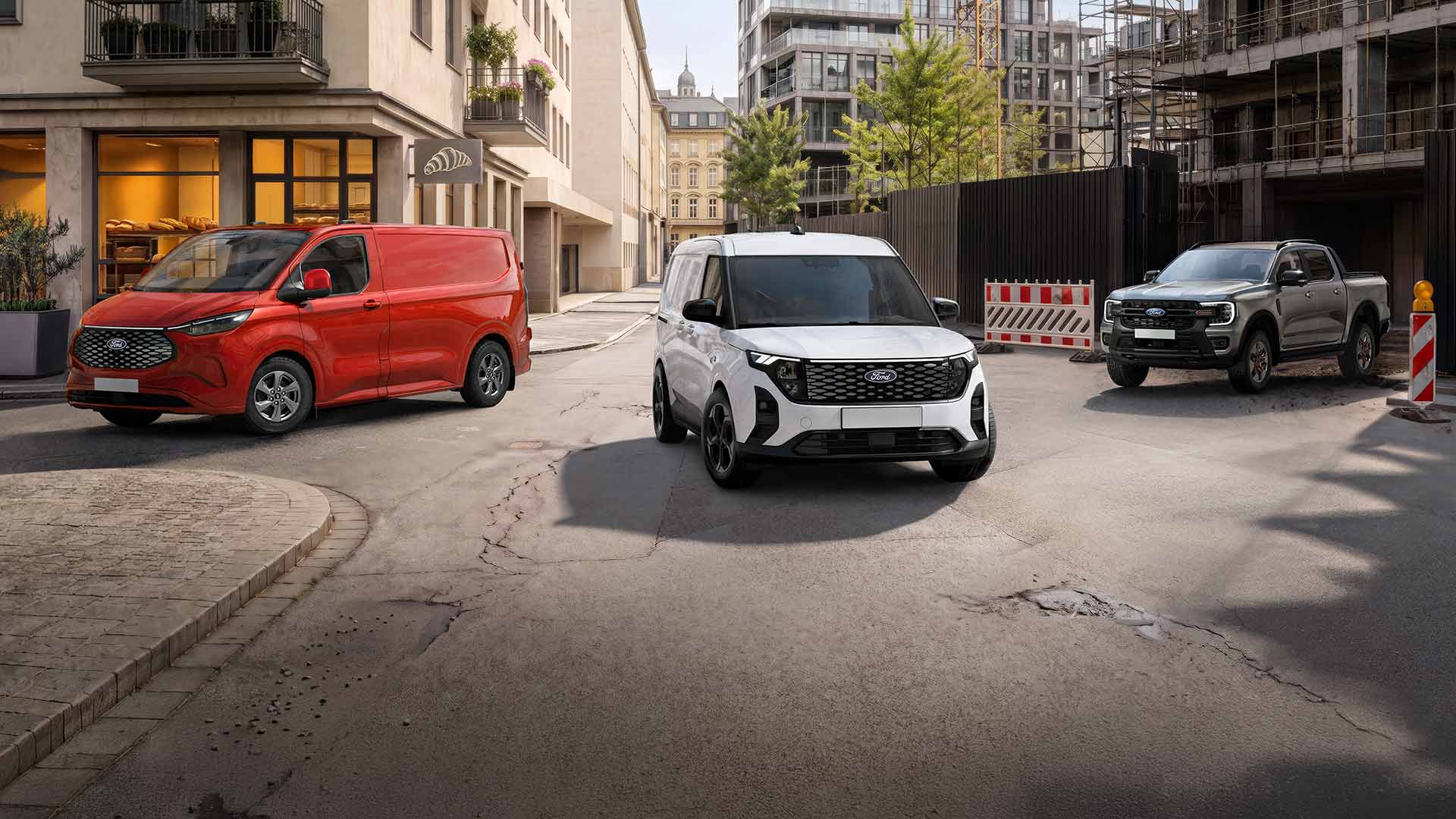 Trois véhicules Ford, un Transit Custom rouge, un E-Transit Custom blanc et un Ranger gris, sont garés dans une rue urbaine.