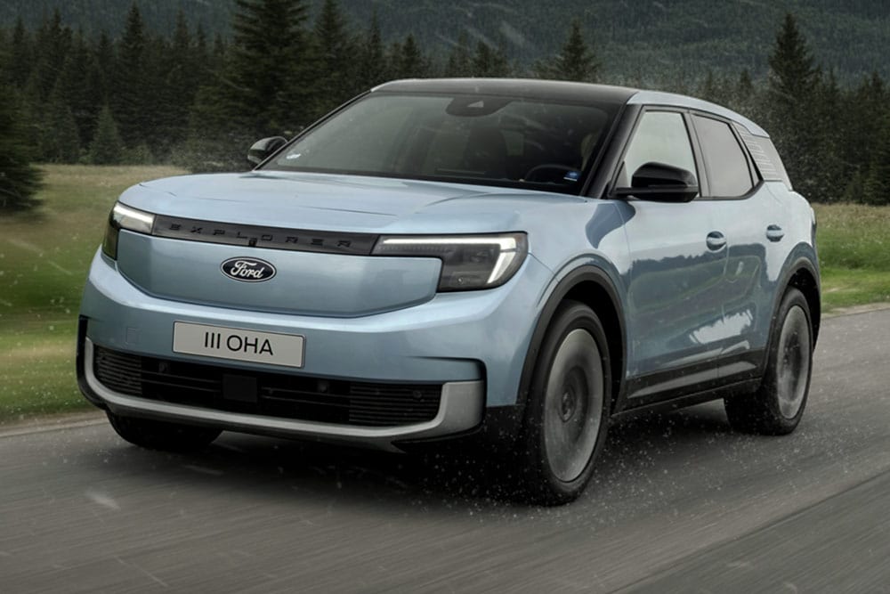 Ford Explorer roulant sur une route de campagne avec des montagnes en arrière-plan