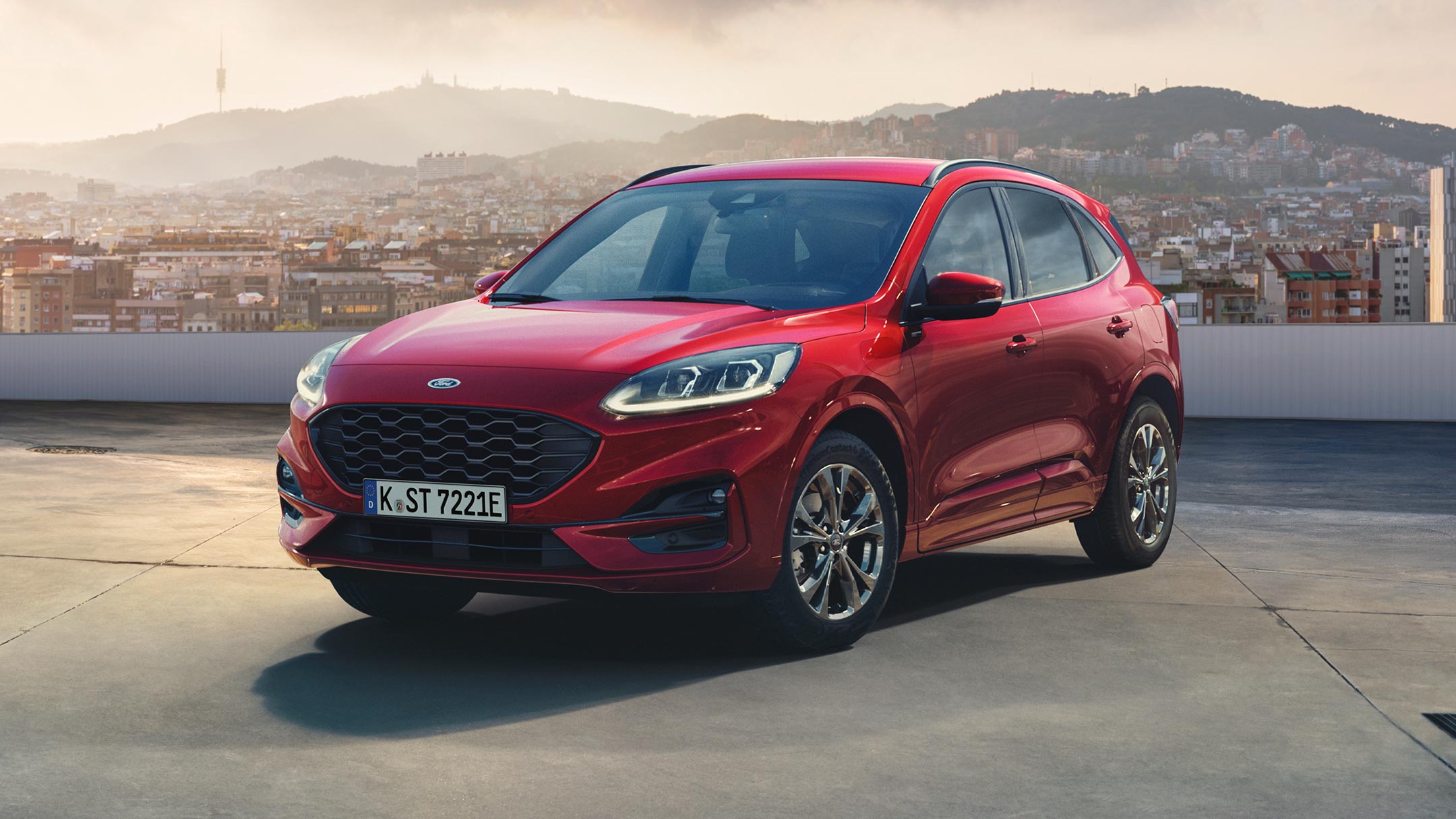 Ford Kuga en rouge, ¾ vue de face debout sur un niveau de parking