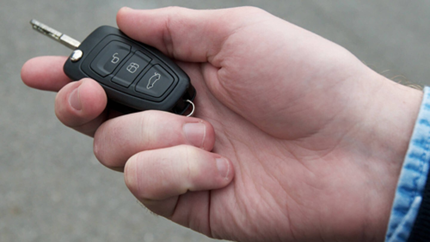 Une main tenant la clé de contact Ford