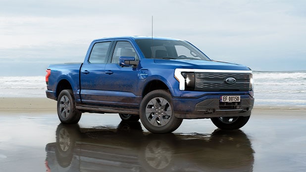 Ford F-150 Lightning bleu garé sur une plage.