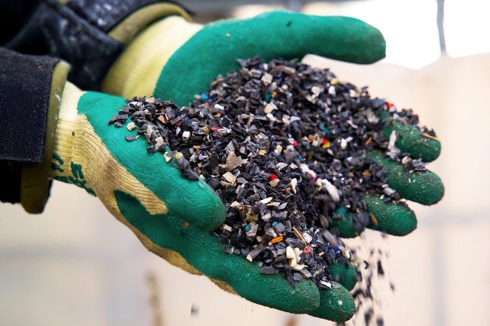 Deux mains tenant des granulés de plastique recyclé