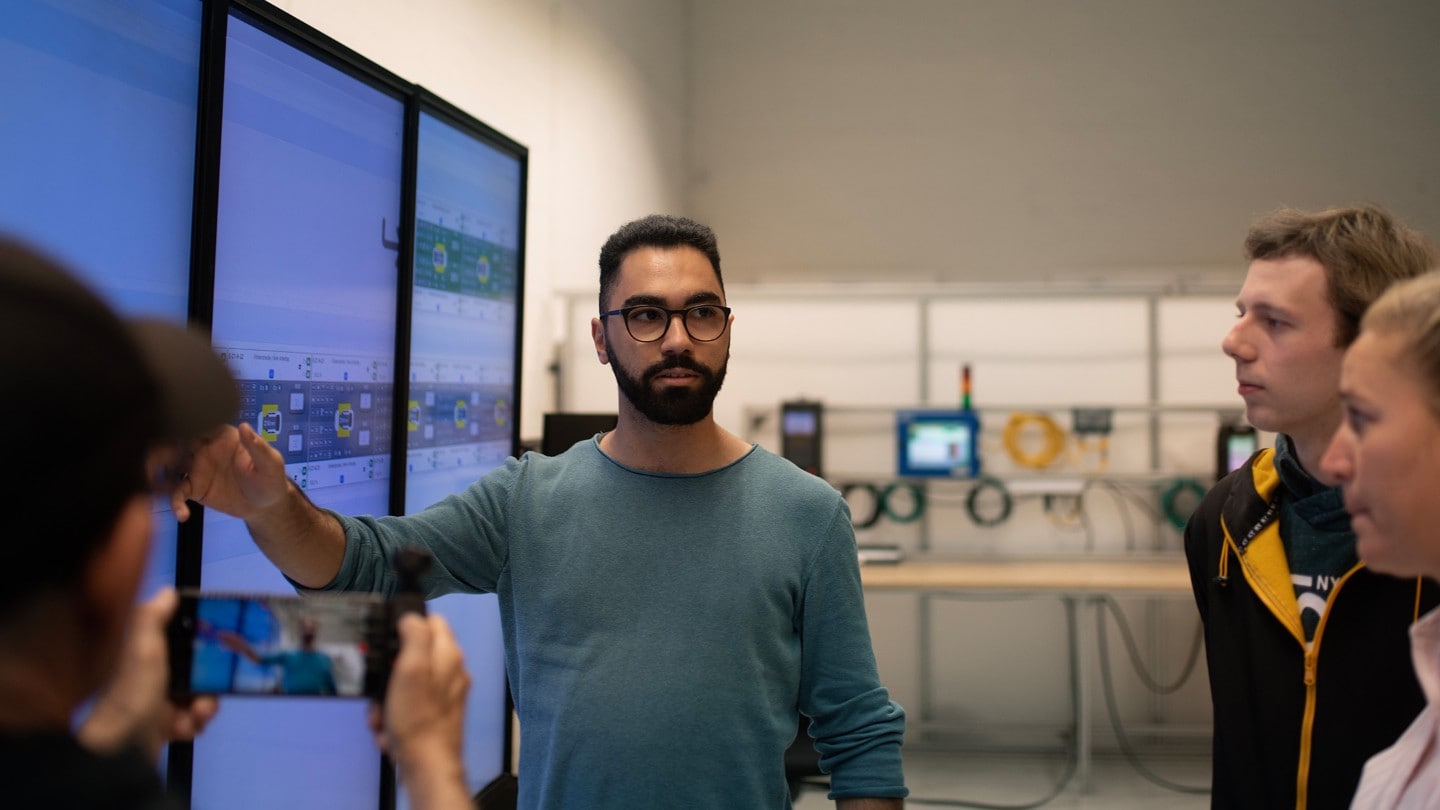 Un homme explique à son équipe un graphique affiché à l’écran