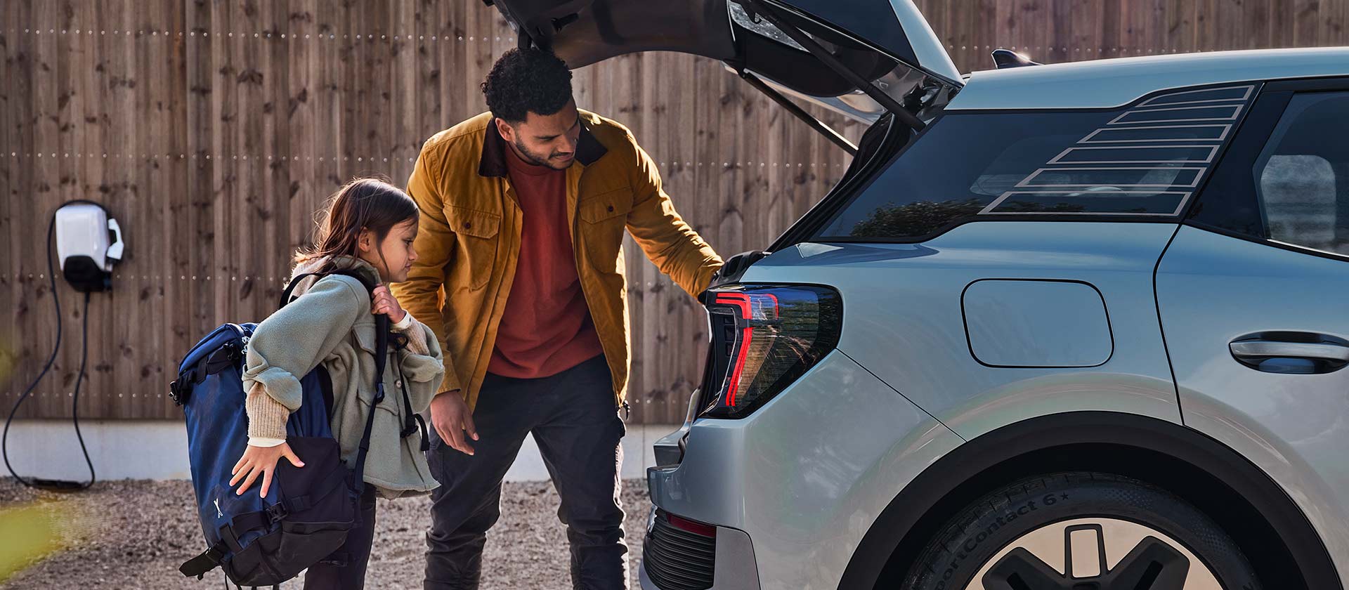 Une famille charge le coffre d’un Ford Explorer électrique bleu.