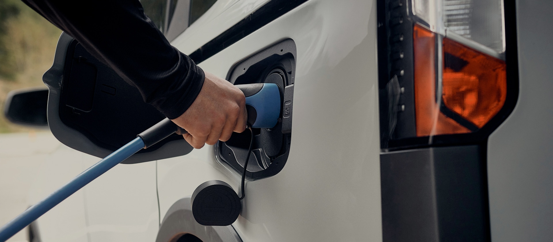 Gros plan d’un véhicule électrique Ford blanc branché sur une borne de recharge.