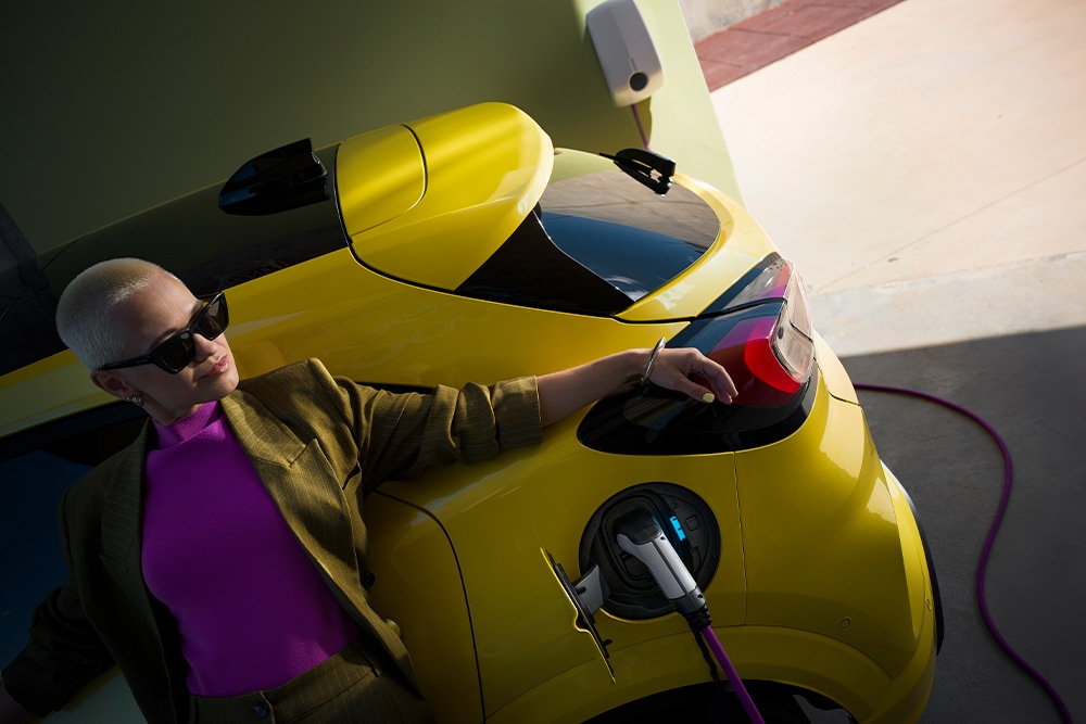 Une personne recharge une Ford Capri électrique jaune. 