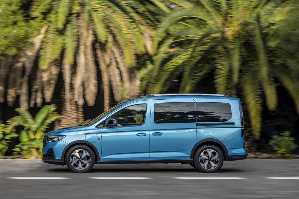 Un Ford Tourneo Connect Plug-in-Hybrid de couleur bleue est garé dans une rue.