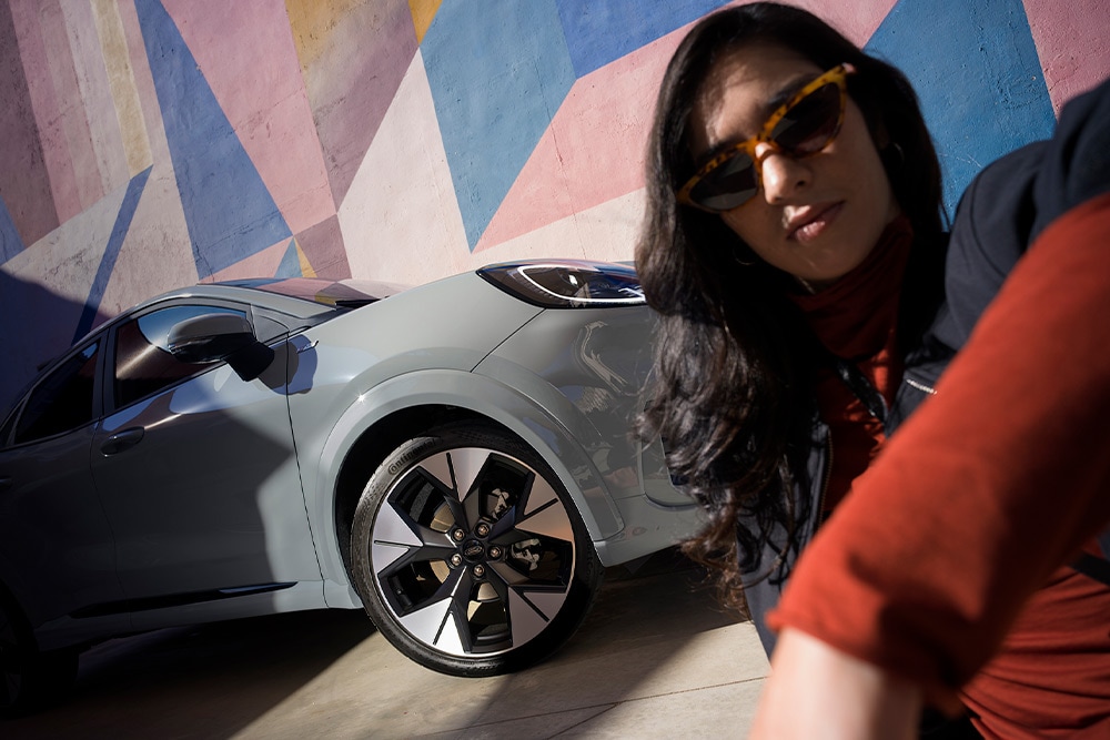 Une personne est assise à côté d’un Ford Puma Mild Hybrid. 