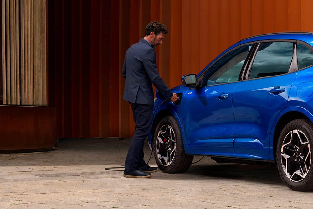 Une personne branche un véhicule Plug-in-Hybrid Ford sur un chargeur.