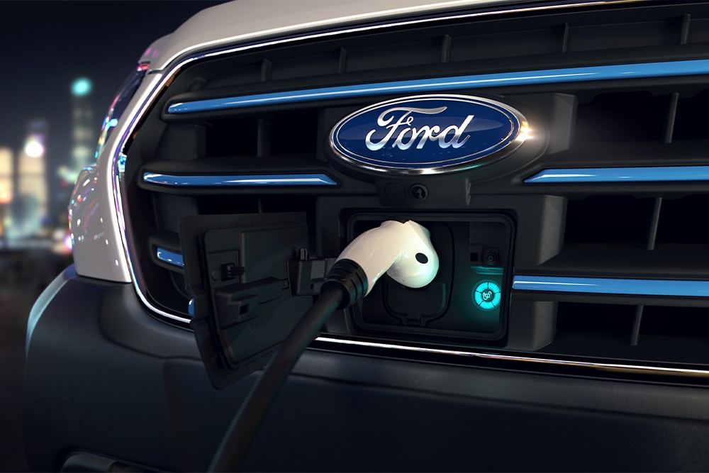 Gros plan d’un Ford E-Transit et du logo ovale bleu de Ford sur la calandre. 