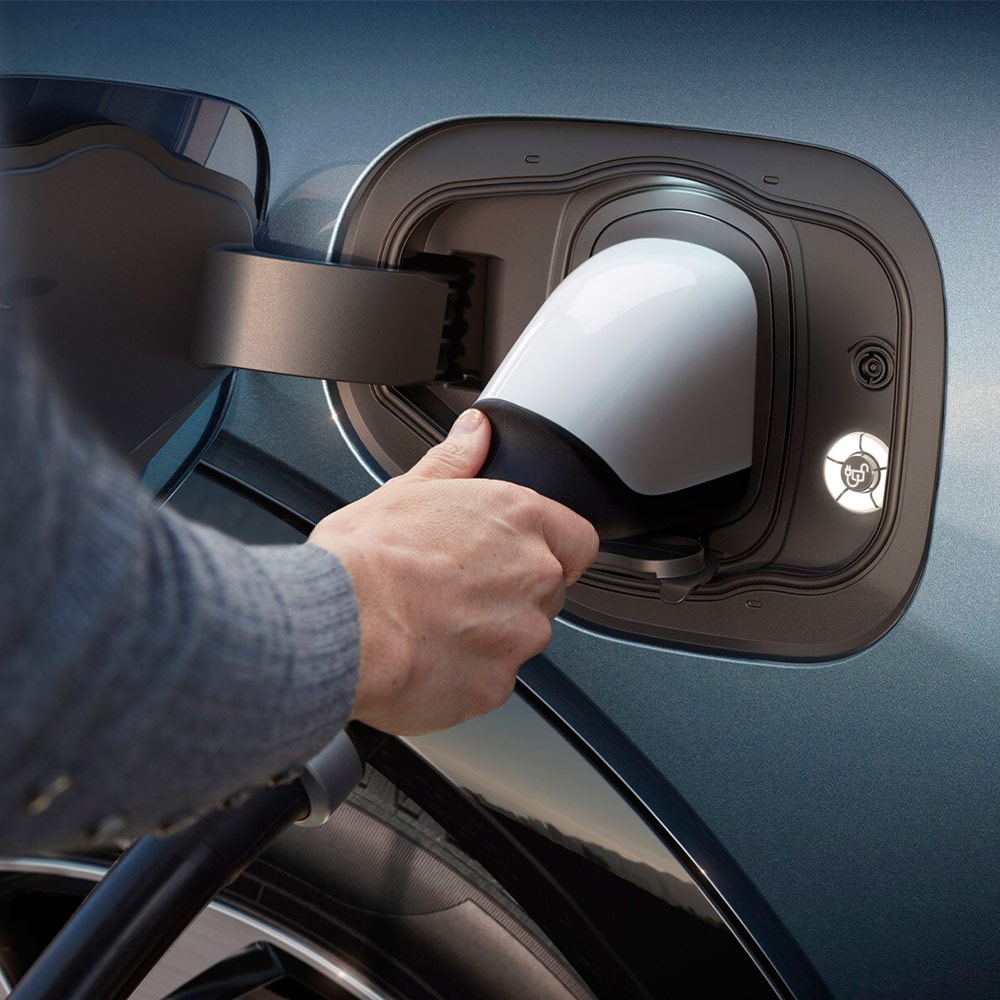 Une personne branche un véhicule électrique Ford sur un chargeur rapide. 