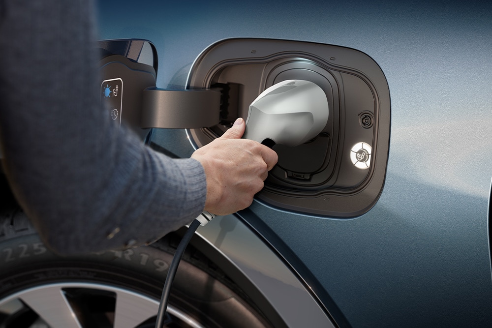 Gros plan d'une personne chargeant un véhicule électrique Ford.
