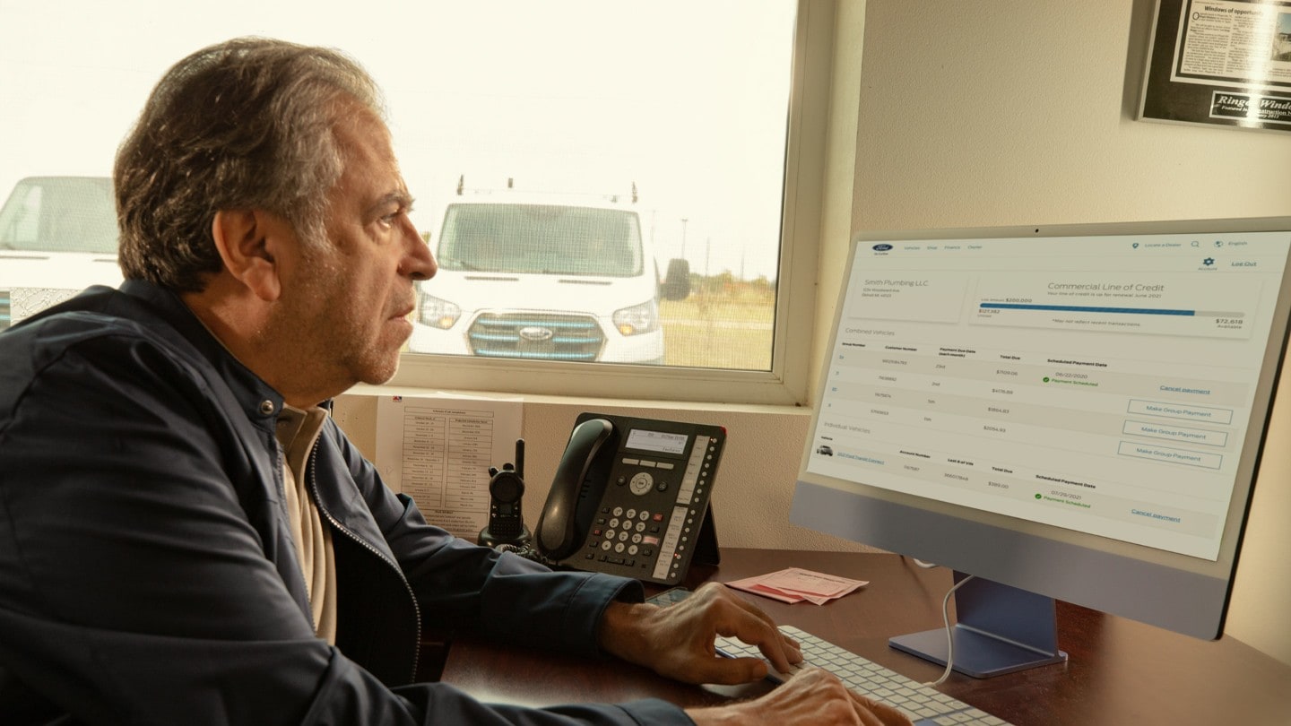 Homme assis au bureau devant un écran d’ordinateur