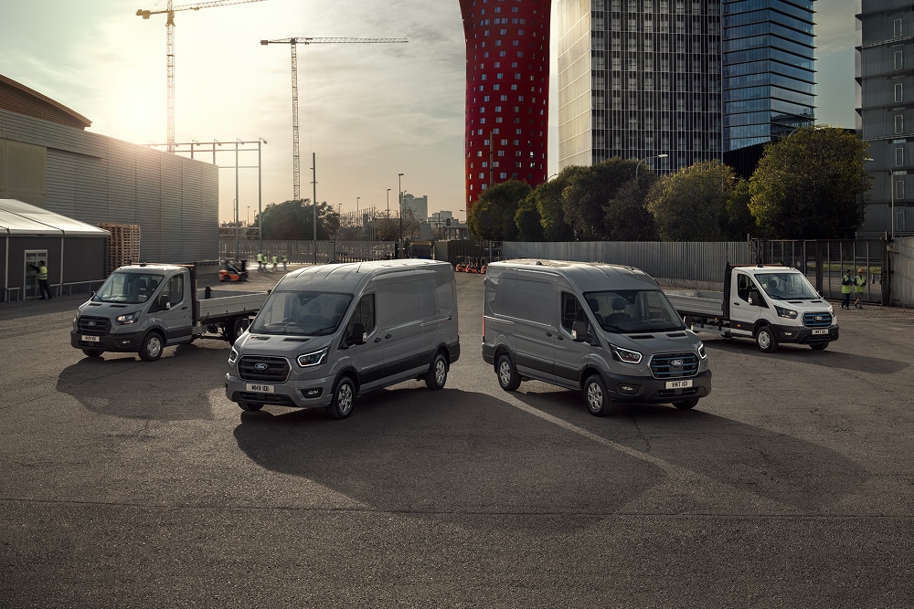 Gamme de fourgons électriques et hybrides rechargeables Ford stationnés dans un parking extérieur.