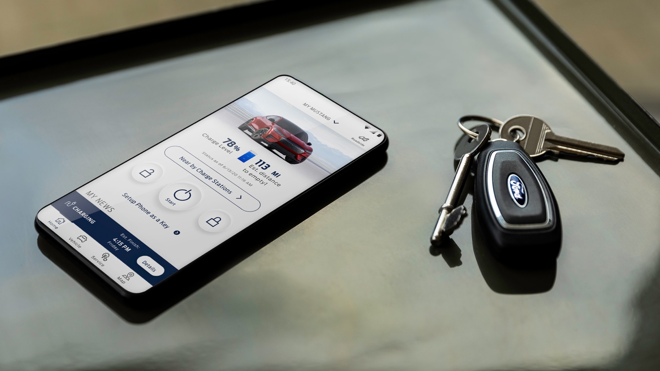 Téléphone avec application FordPass ouverte posé sur un bureau à côté de clés de voiture 