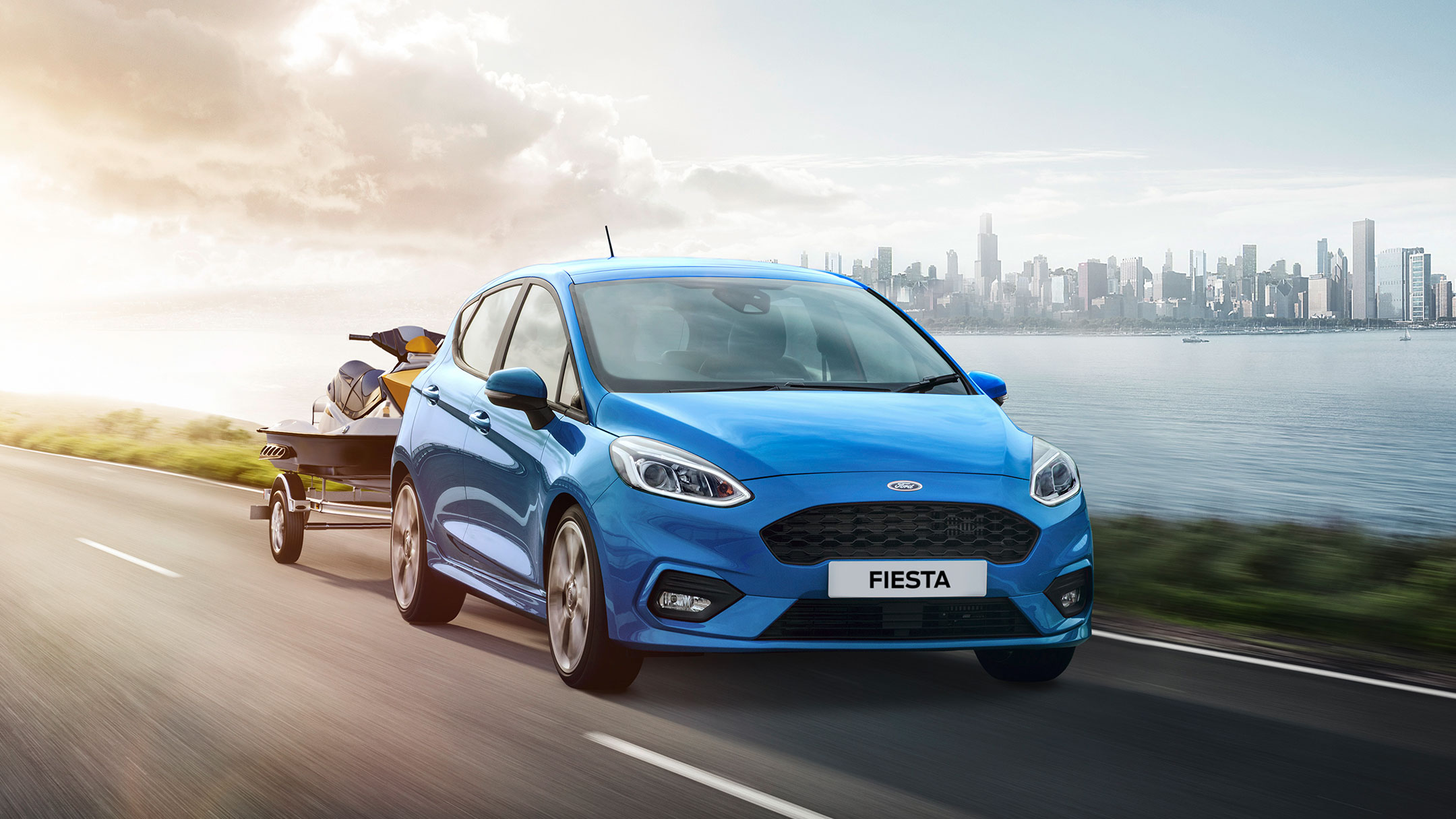 Ford Fiesta ST couleur bleue. Vue de face aux trois quarts avec jet ski remorqué.