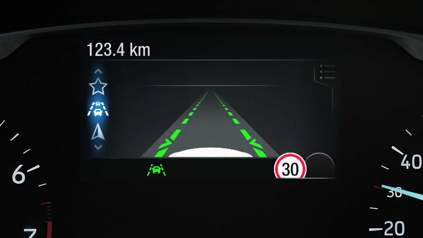 Vue détaillée du tableau de bord numérique en conduite de nuit.