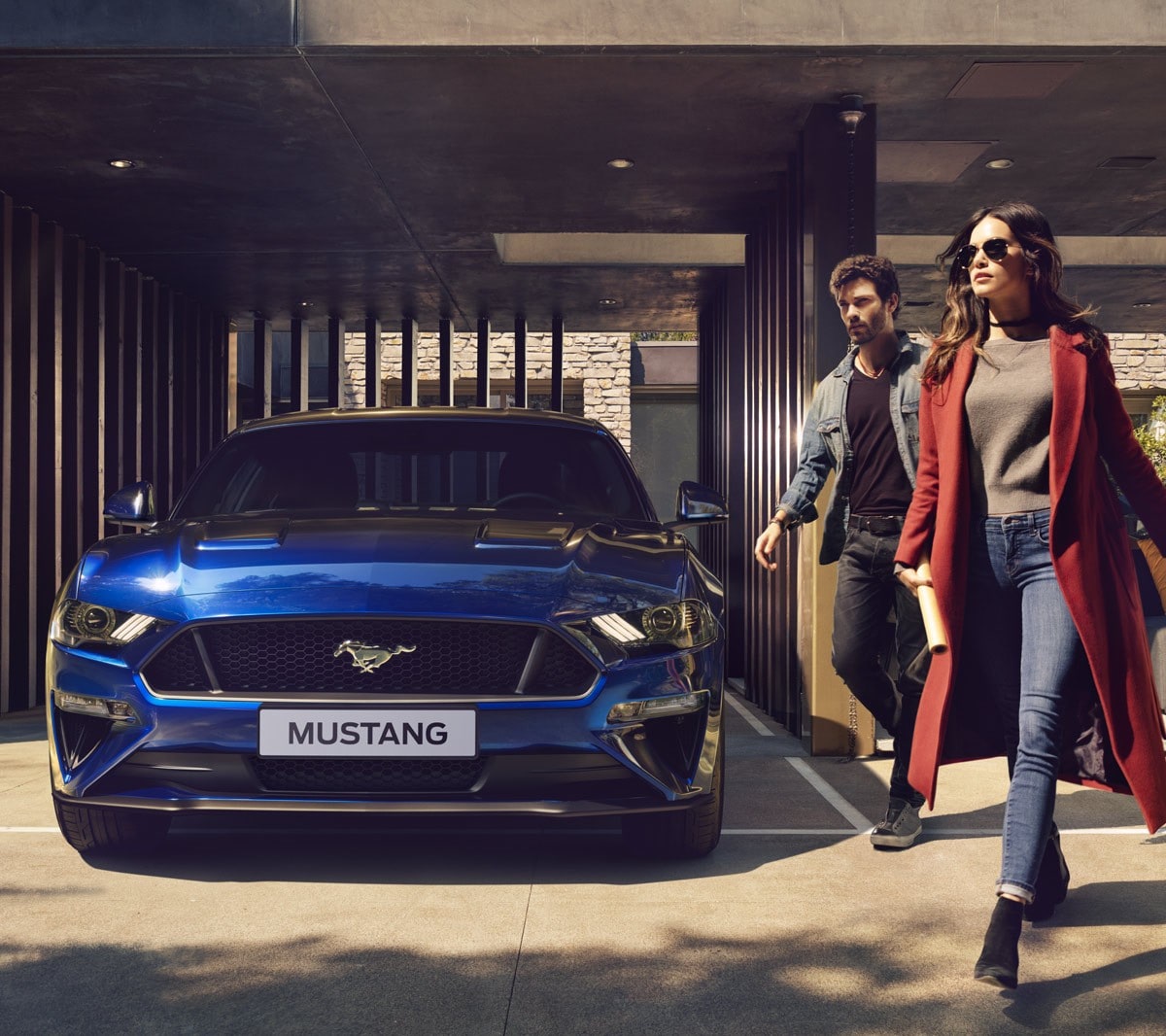 Ford Mustang GT bleue garée près d'un portail de grillage