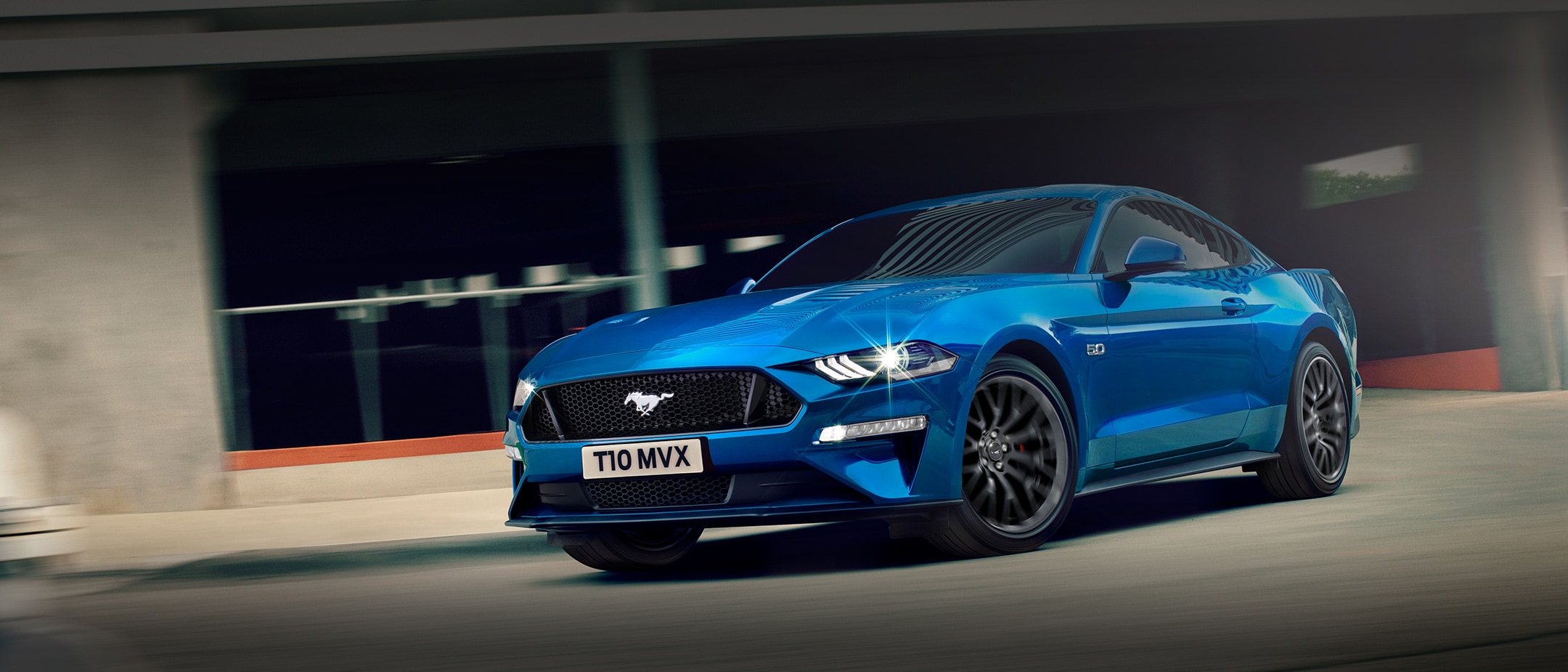 Ford Mustang GT couleur bleue. Vue de face aux trois quarts, roulant en ville.