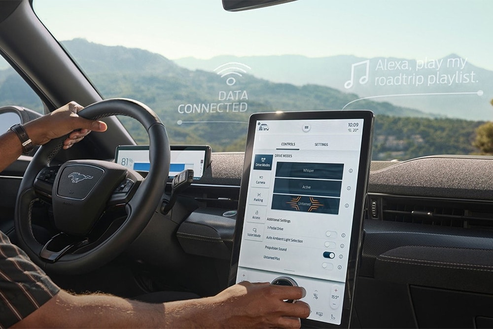 Gros plan sur le conducteur d’une Ford Mustang Mach-E utilisant le grand écran tactile SYNC 4 de 15.5 pouces.