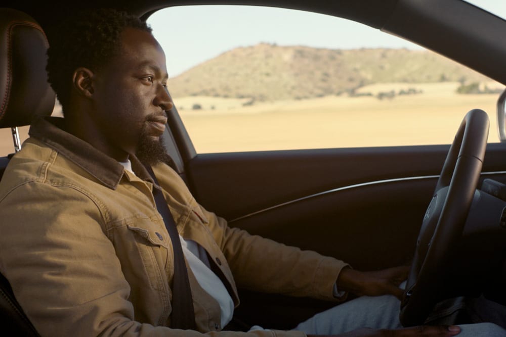 Un homme conduit une Ford Mustang Mach-E et utilise la technologie Ford BlueCruise «hands-off, eyes-on».