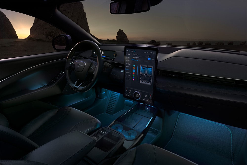 Ford Mustang Mach-E la nuit, avec l’écran tactile SYNC 4 de 15.5 pouces et l’éclairage d’ambiance à LED réglé sur la couleur bleue.