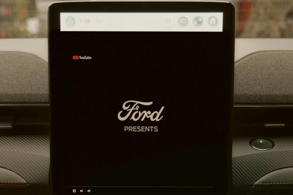 Écran tactile SYNC 4 de 15.5 pouces avec un graphique montrant «Ford PRESENTS» et illustrant le streaming vidéo en voiture.