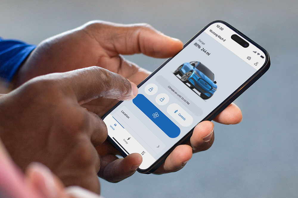 Gros plan sur un iPhone avec l’application FordPass ouverte, montrant une photo d’une Ford Mustang Mach-E et plusieurs boutons.