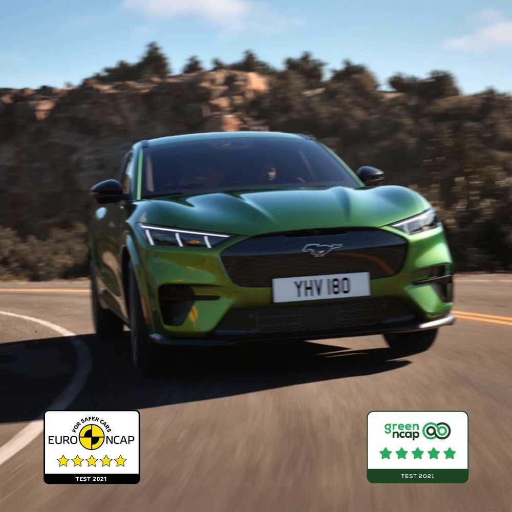 Une Ford Mustang Mach-E GT de couleur verte roule sur une route de montagne.
