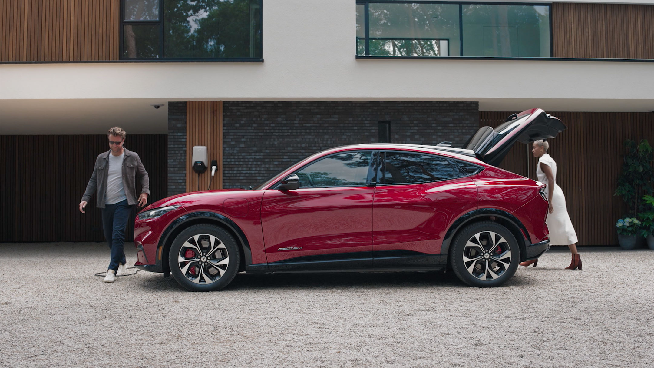 Ford Mustang Mach-E AWD en rouge. Vue latérale avec hayon ouvert