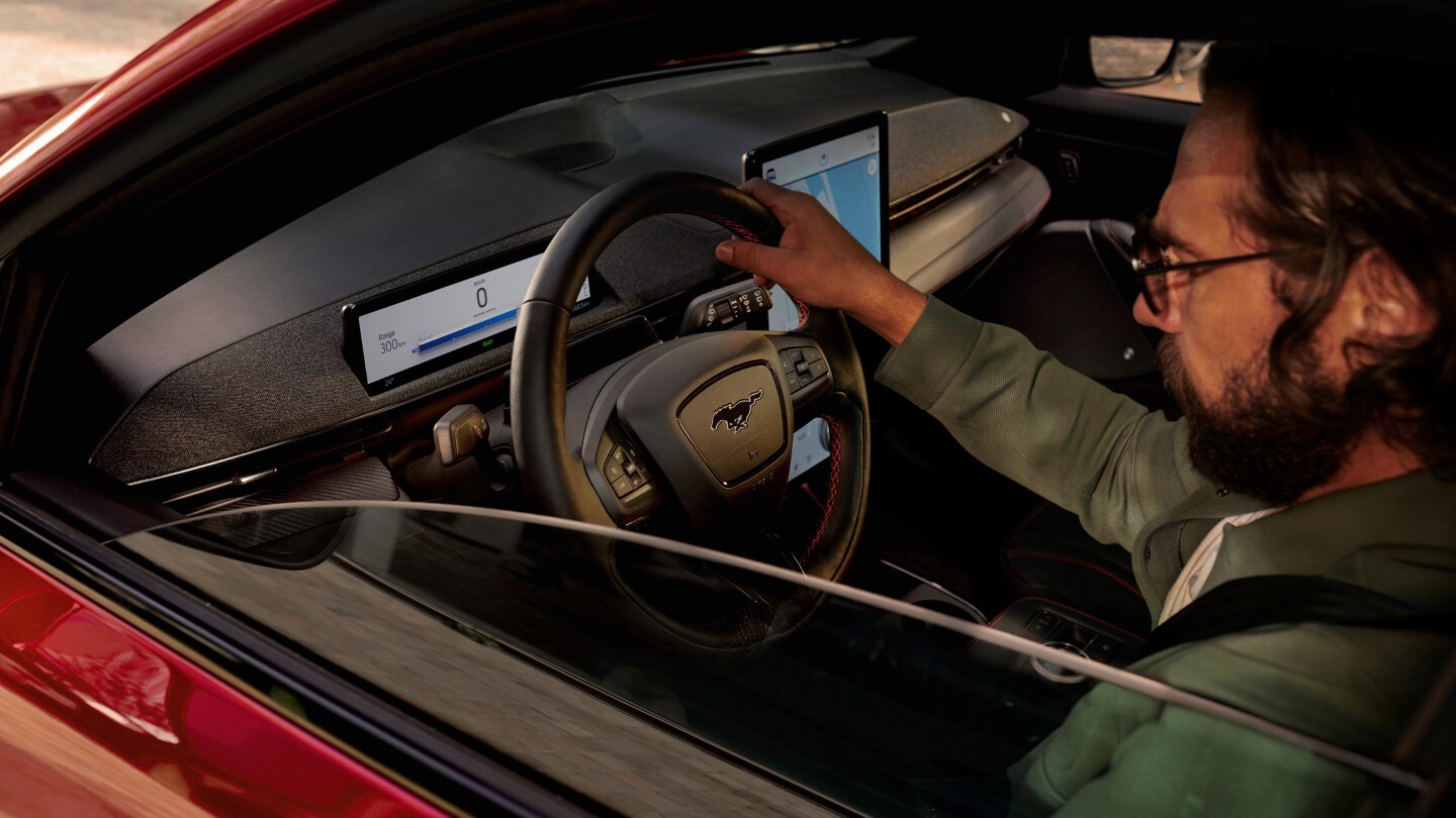 Ford Mustang Mach-E. Vue à travers la fenêtre latérale sur le conducteur au volant