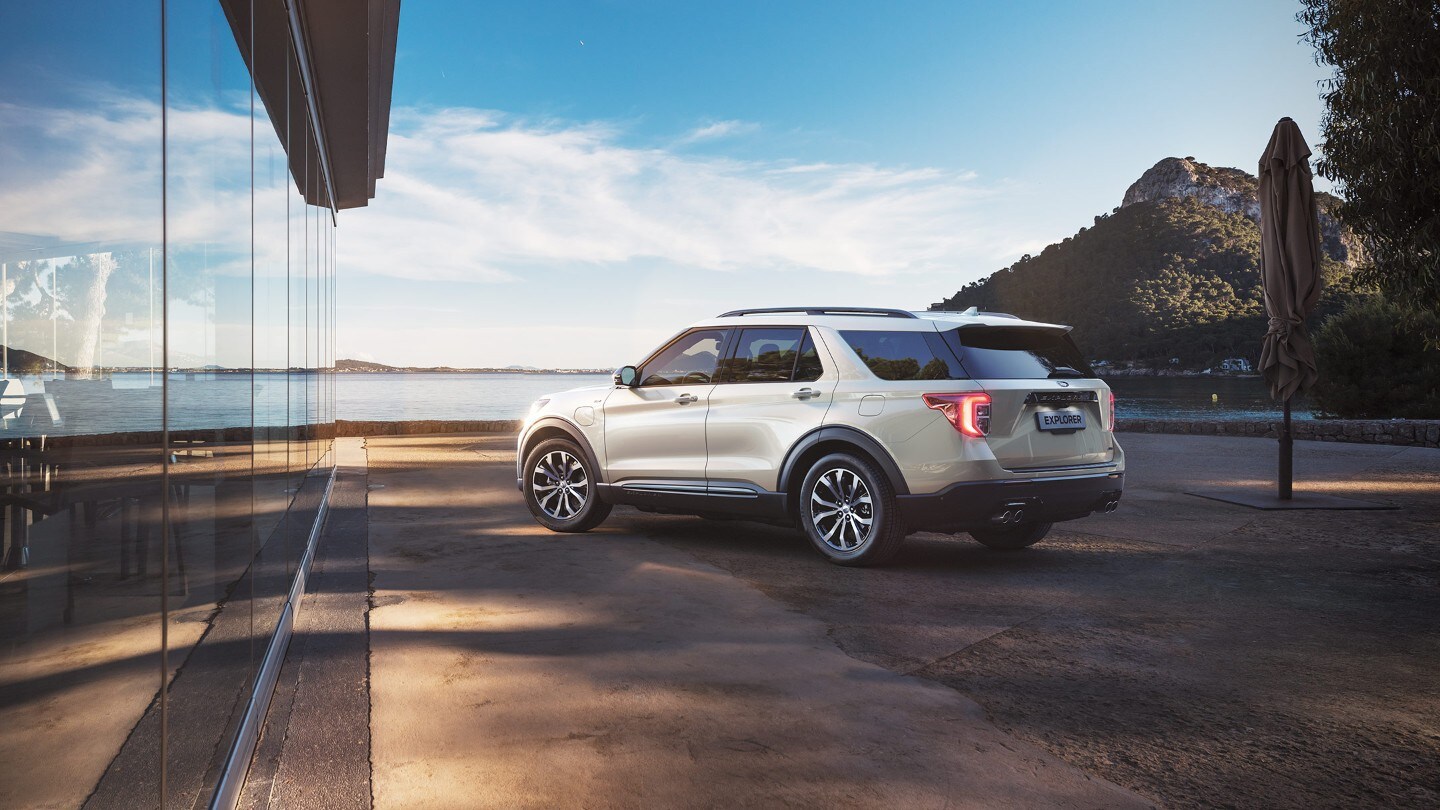 Ford Explorer Plug-In Hybrid blanc. Vue trois-quarts arrière. Stationnement sur une plage