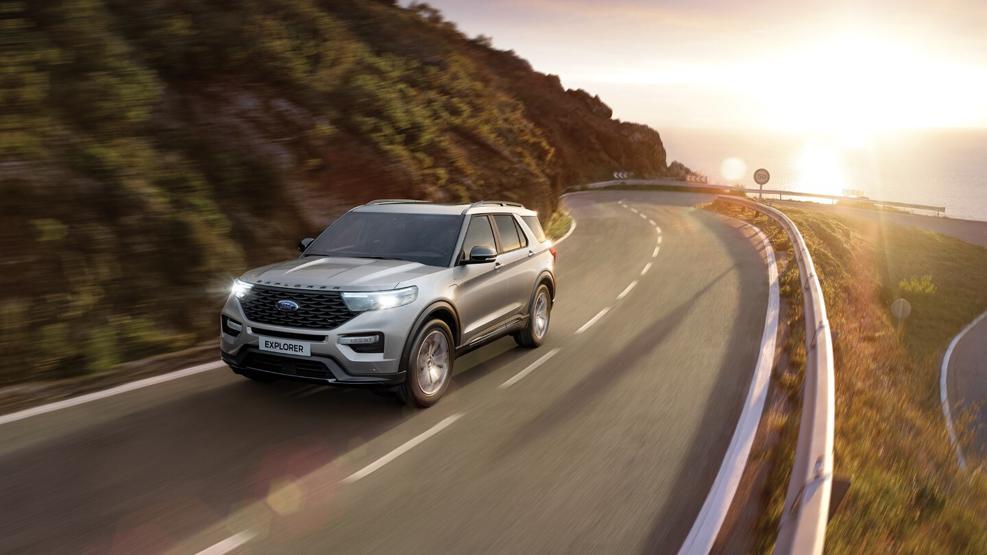 Ford Explorer Plug-In Hybrid de couleur argent. Conduite sur une route de campagne sinueuse 