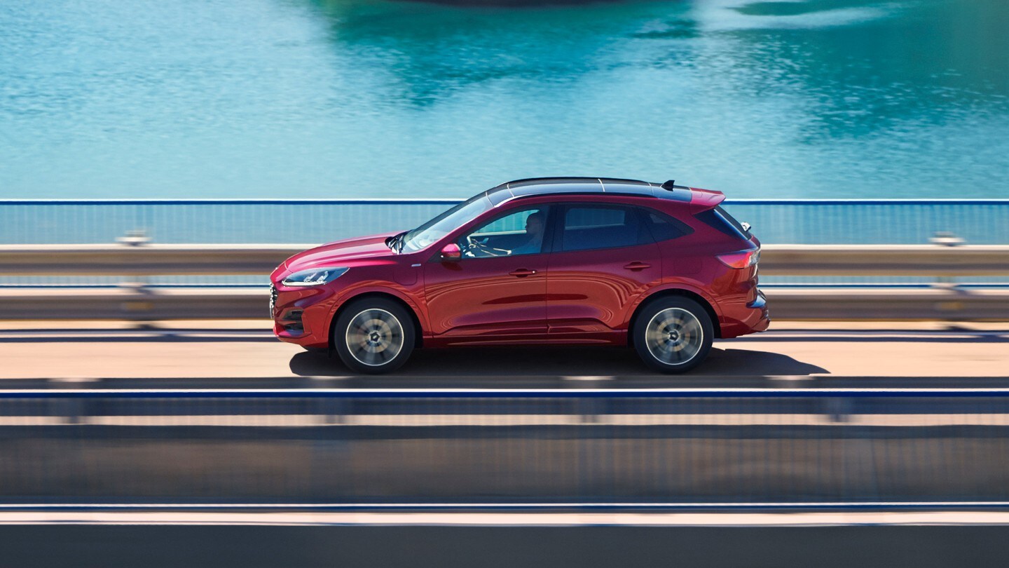 Ford Kuga rouge, vue latérale, roulant sur un pont