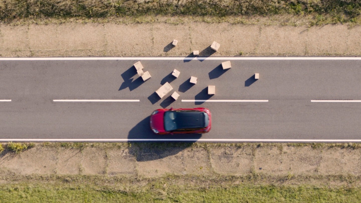 Ford Kuga couleur rouge. Éviter les obstacles sur une route de campagne