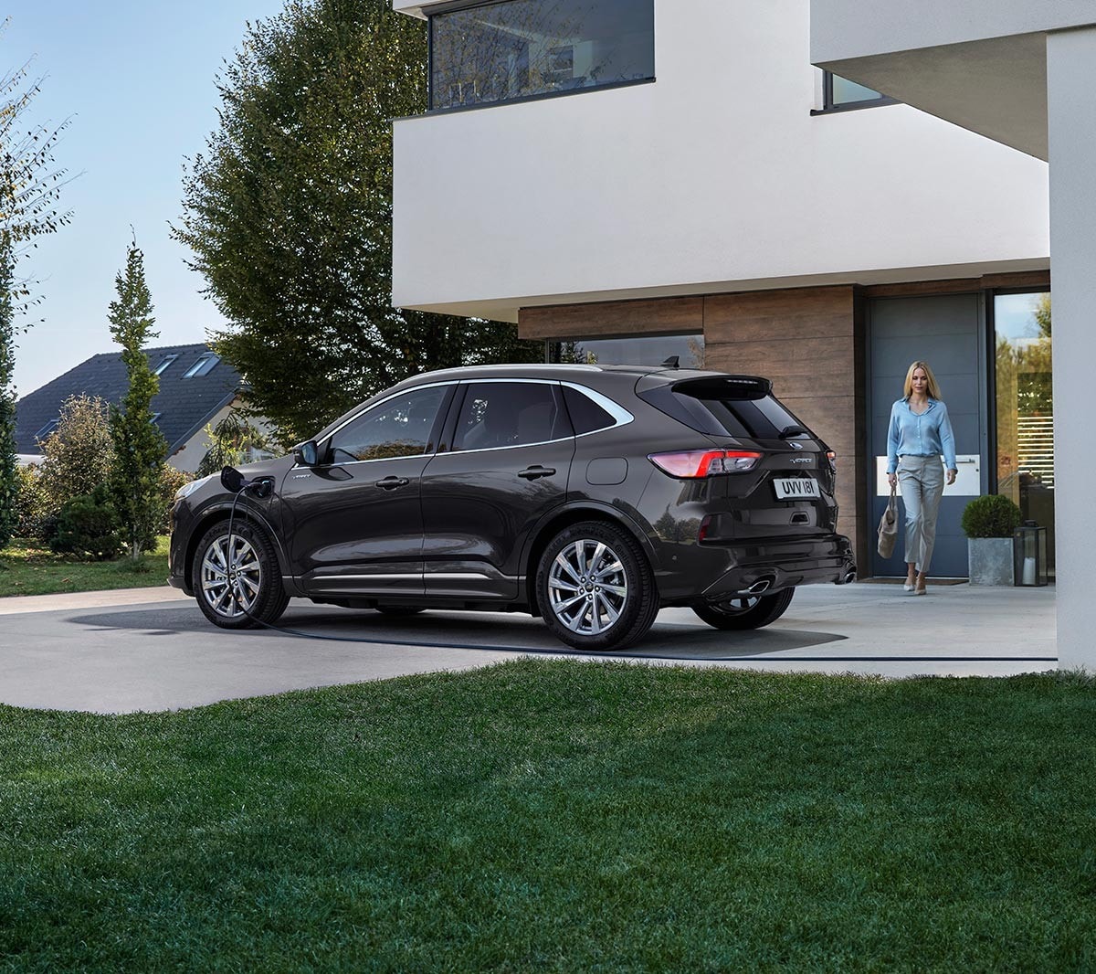 Ford Kuga couleur bleue. Vue latérale, garé devant un bâtiment moderne