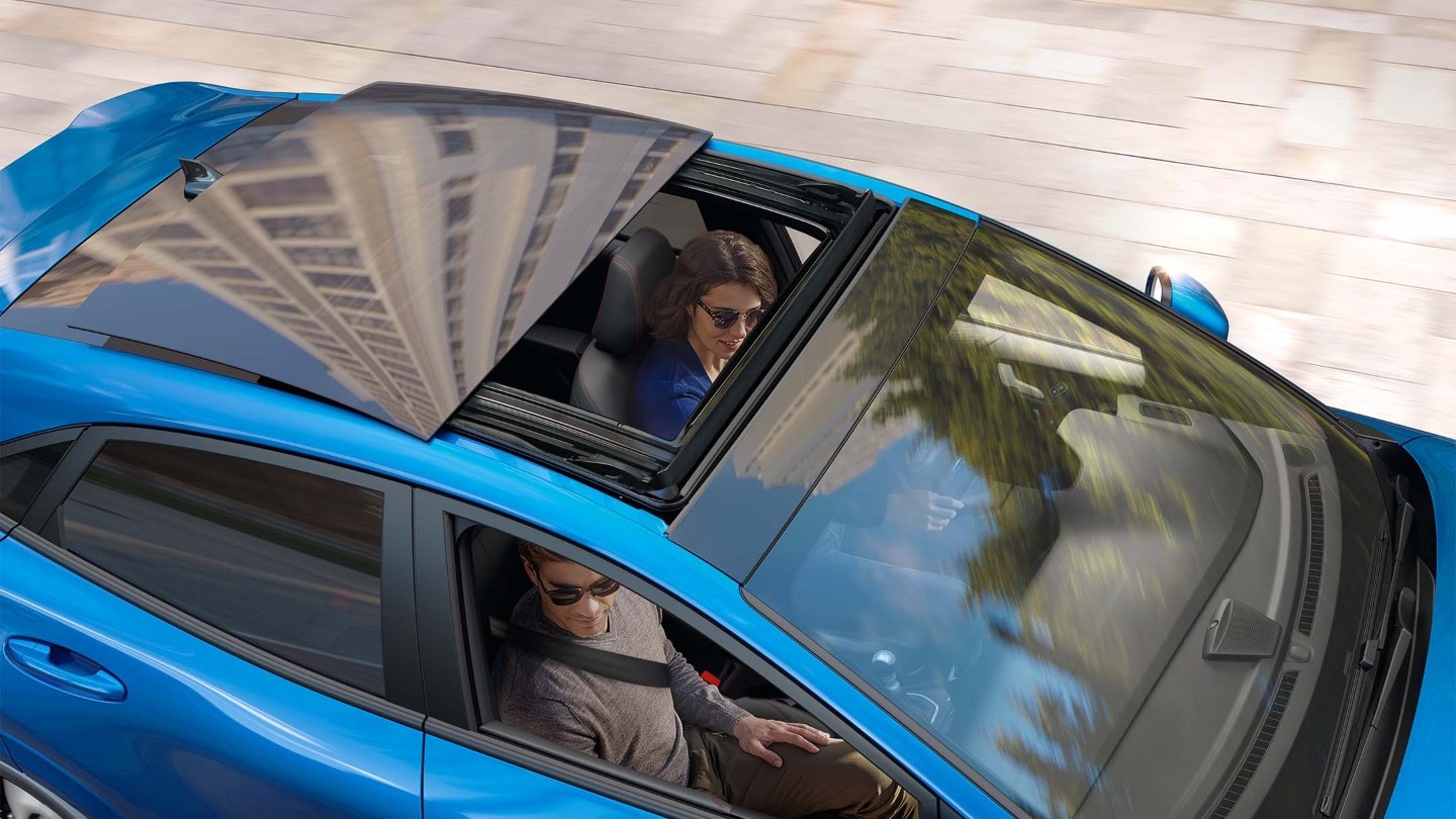 Le Ford Puma à l'intérieur, la conductrice ouvre le toit coulissant panoramique électrique