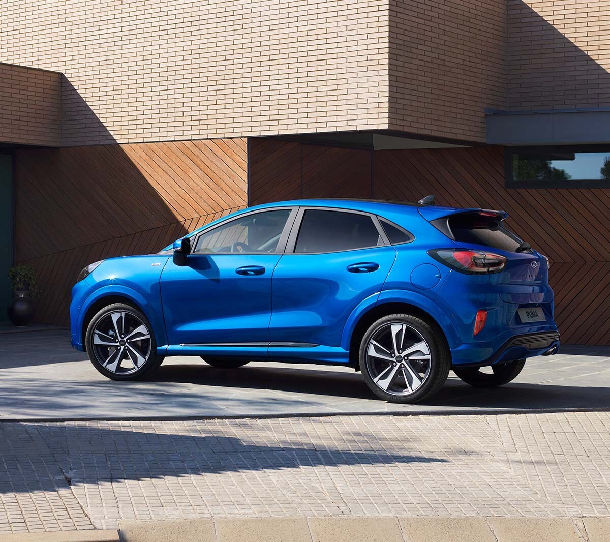 Ford Puma ST-Line X couleur bleue, vue latérale, devant une maison.