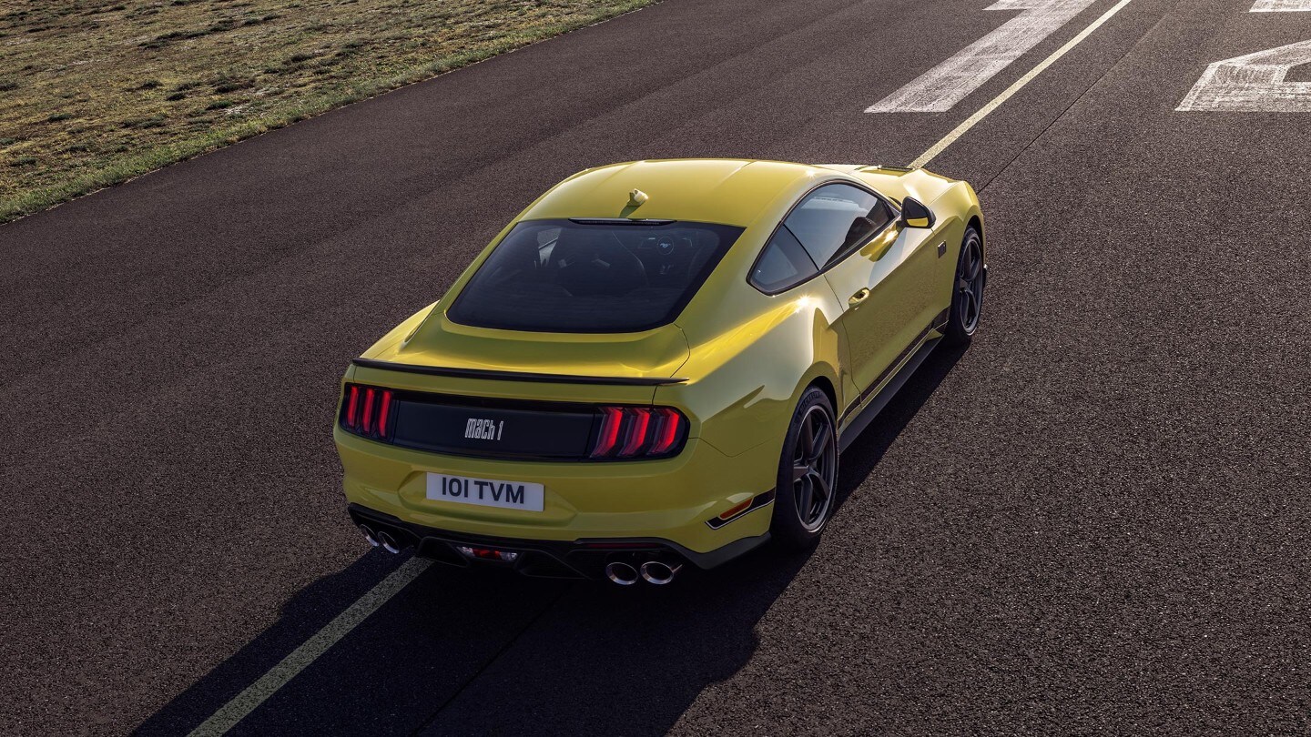 Ford Mustang Mach 1 couleur jaune. Vue arrière aux trois quarts, conduite sur piste