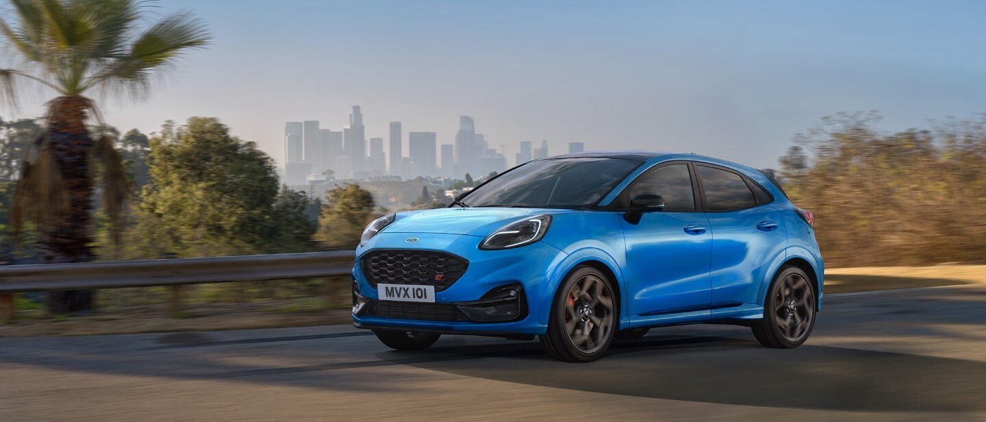 Ford Puma ST Powershift couleur bleue, vue de face aux trois quarts, roulant sur une route