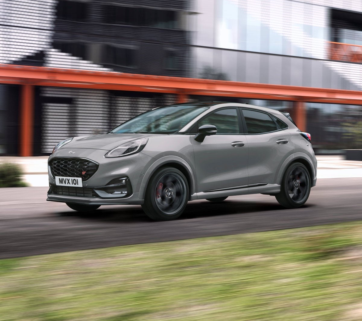 Ford Puma ST couleur grise, vue de face aux trois quarts, dans une rue devant un bâtiment moderne