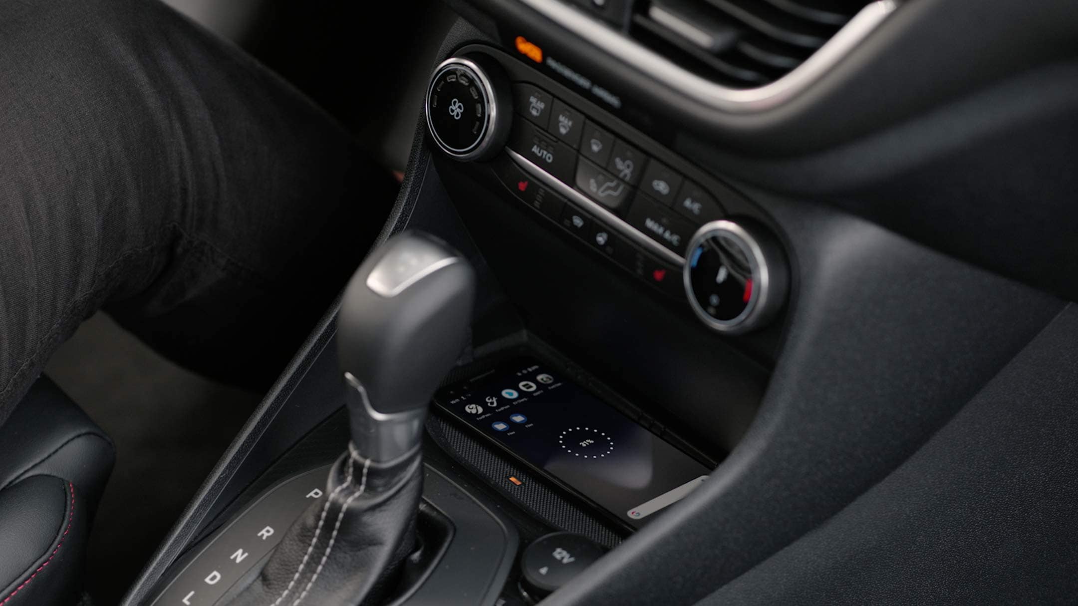 Ford Fiesta ST. Vue détaillée de l’intérieur avec pommeau de levier de vitesses et console centrale pour le chargement sans fil.