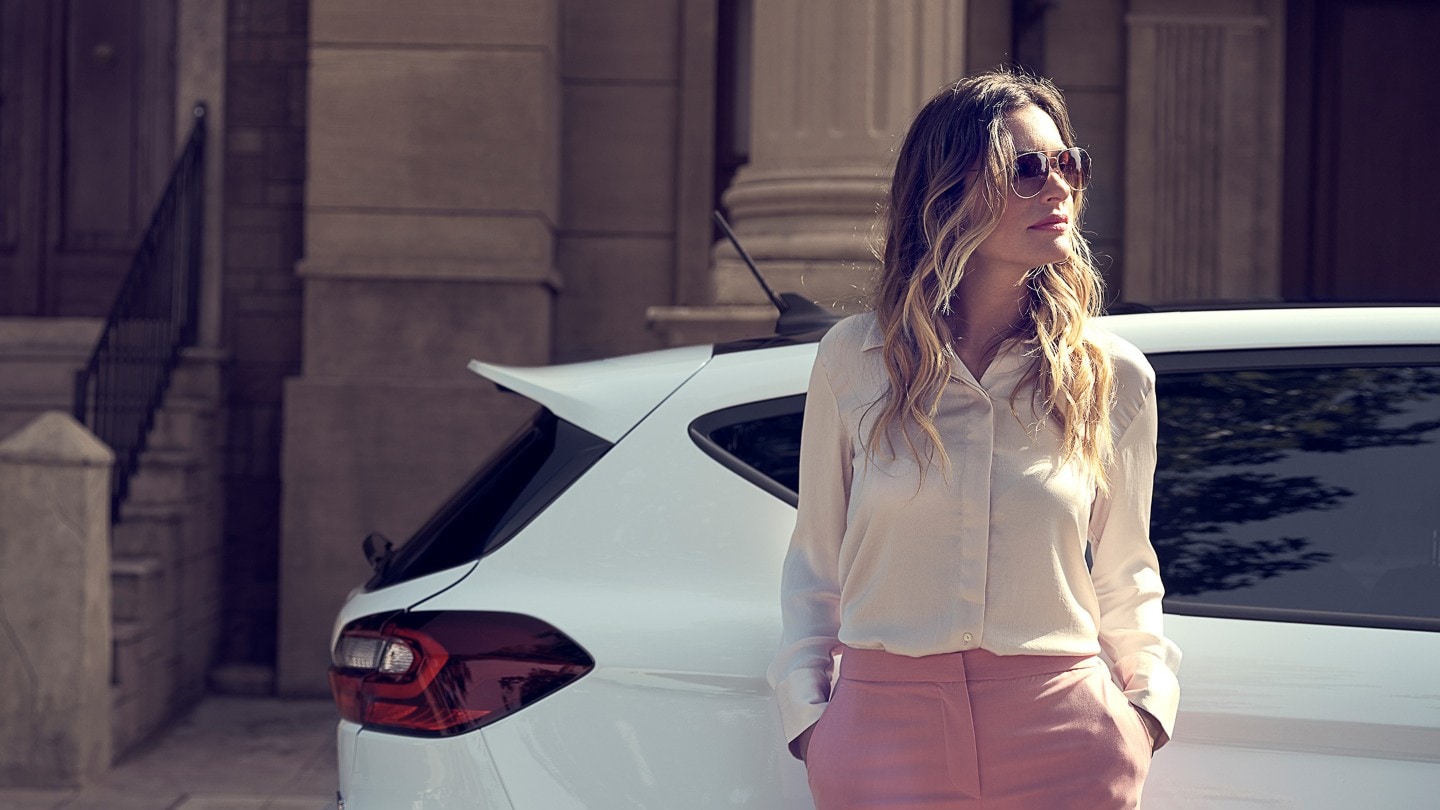 Ford Fiesta couleur blanche. Vue latérale, avec femme au premier plan.