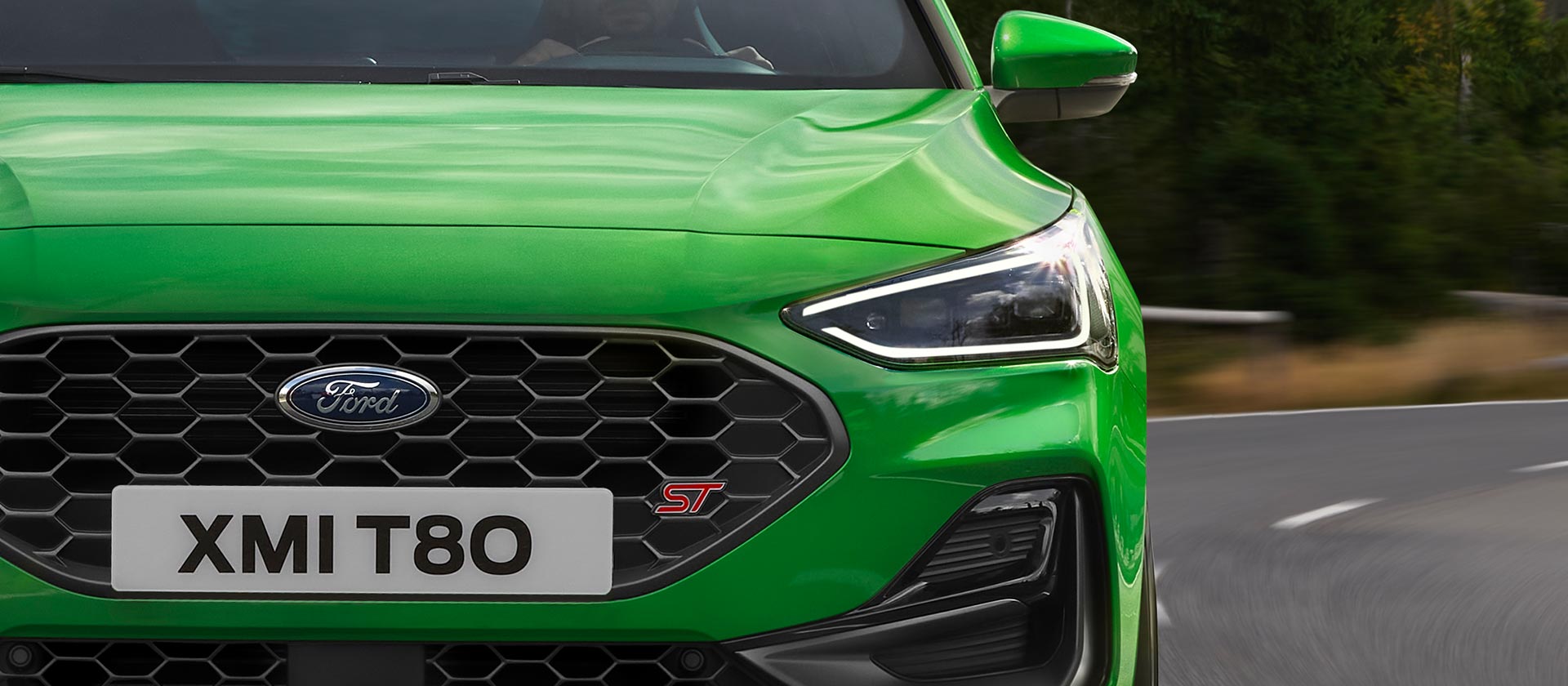 Vue de face de la Ford Focus ST de couleur Mean Green, montrant la calandre en nid-d’abeilles et l’emblème ST.