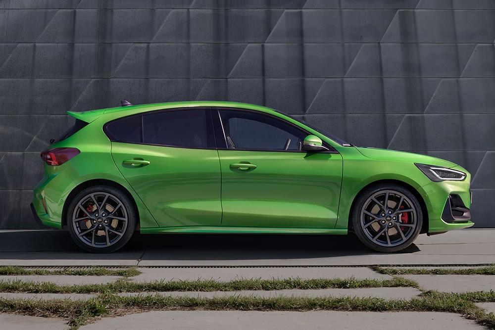 Une Ford Focus ST à hayon de couleur Mean Green est garée sur le côté, à l’écart de la route.